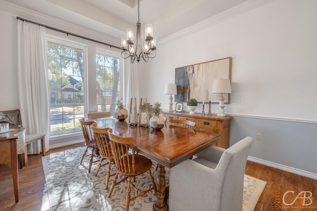 dining room with dark hardwood / wood-style flooring, a notable chandelier, and ornamental molding