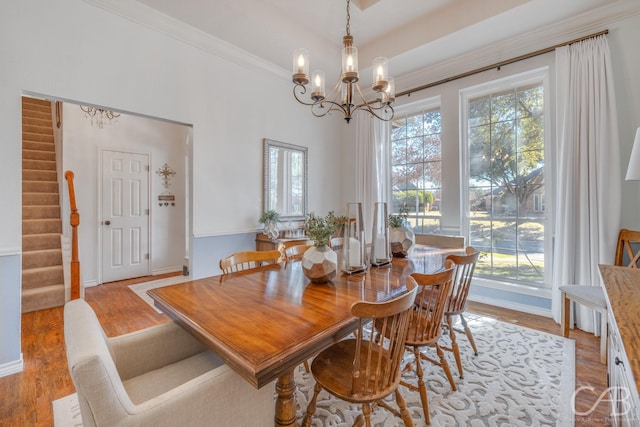 dining room with crown molding, a notable chandelier, and light hardwood / wood-style flooring