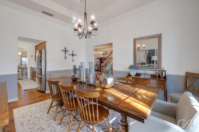 dining area with crown molding, hardwood / wood-style flooring, and a chandelier