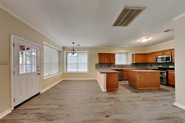 kitchen featuring decorative light fixtures, light hardwood / wood-style flooring, stainless steel appliances, and a kitchen island