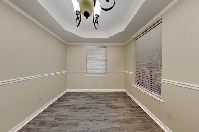 spare room with hardwood / wood-style flooring, crown molding, and a tray ceiling