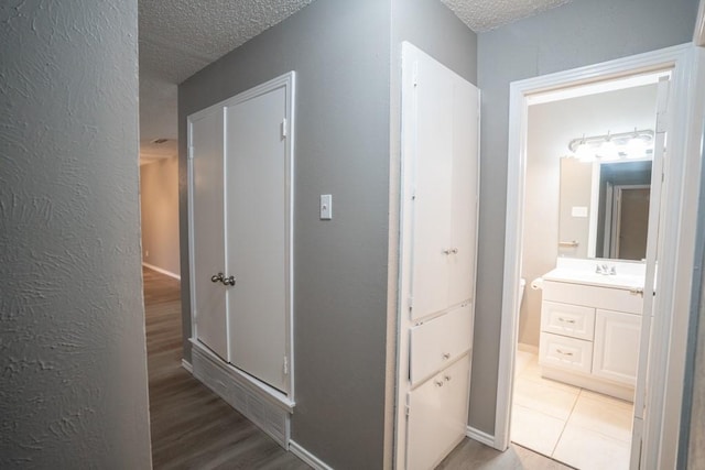 corridor featuring tile patterned floors and a textured ceiling