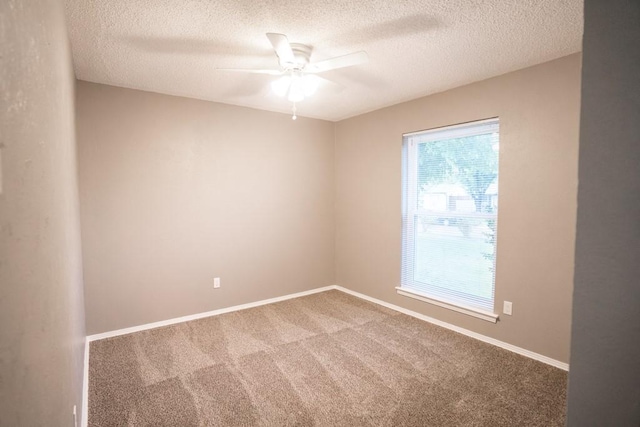 carpeted spare room featuring ceiling fan and a textured ceiling