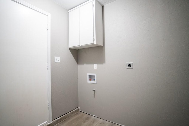 laundry room with cabinets, hookup for a washing machine, hookup for an electric dryer, and light wood-type flooring