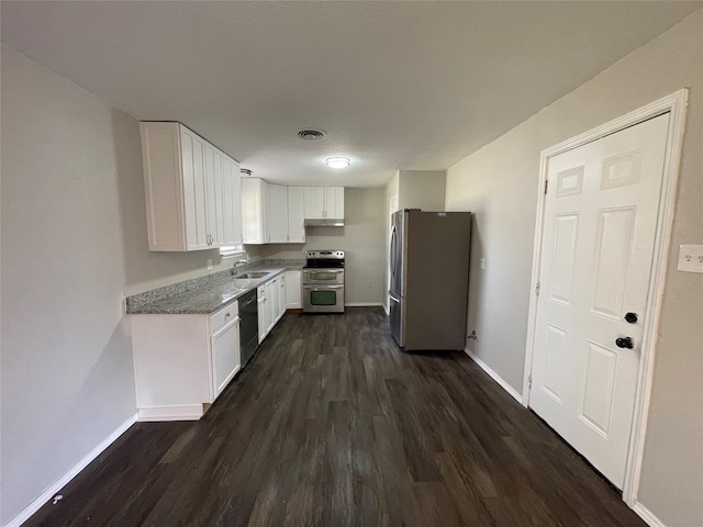 kitchen featuring appliances with stainless steel finishes, sink, white cabinets, dark hardwood / wood-style flooring, and light stone counters