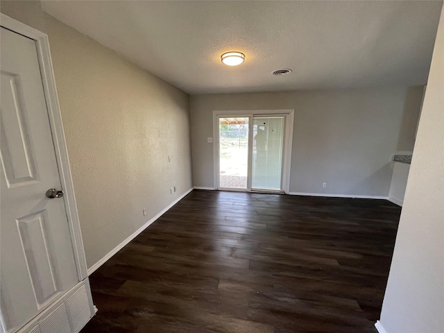 unfurnished room with dark hardwood / wood-style floors and a textured ceiling