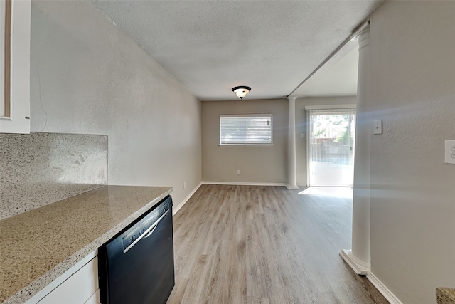 kitchen with decorative columns, white cabinetry, a textured ceiling, dishwasher, and light hardwood / wood-style floors