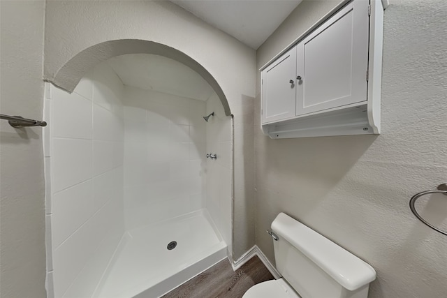 bathroom featuring hardwood / wood-style flooring, toilet, and walk in shower