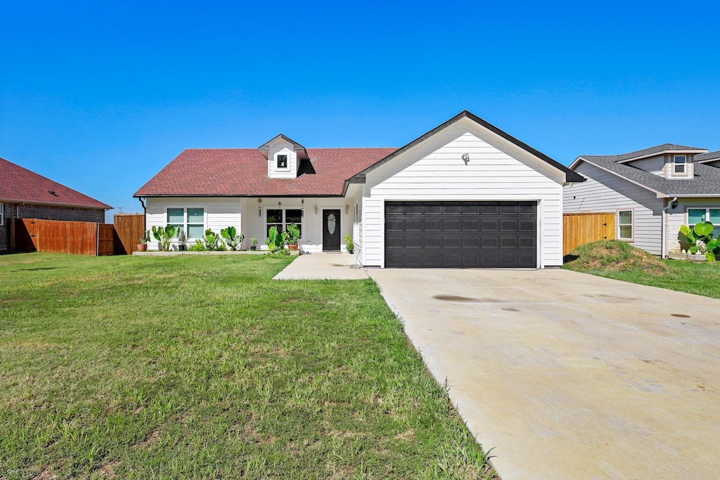 view of front of property with a garage and a front lawn