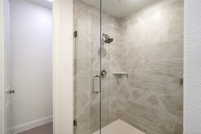 bathroom featuring wood-type flooring and a shower with door