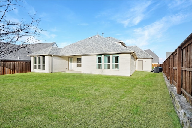 rear view of house featuring a yard and central air condition unit