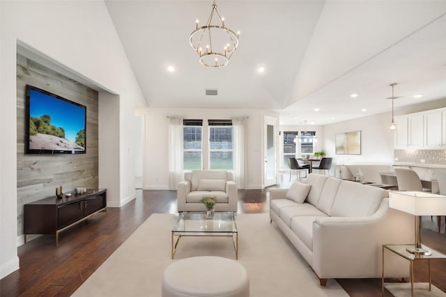 living room with vaulted ceiling, dark hardwood / wood-style floors, and a notable chandelier