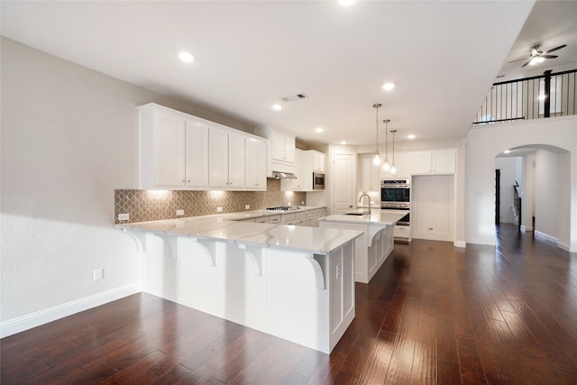 kitchen with white cabinetry, a breakfast bar area, and pendant lighting