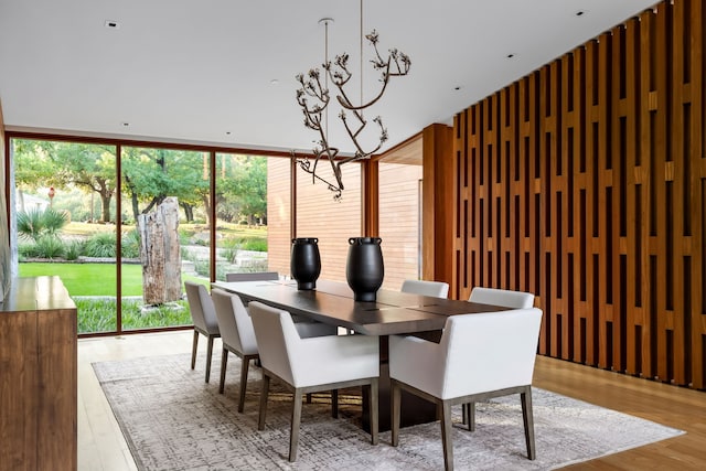 dining space featuring expansive windows, an inviting chandelier, and light hardwood / wood-style flooring