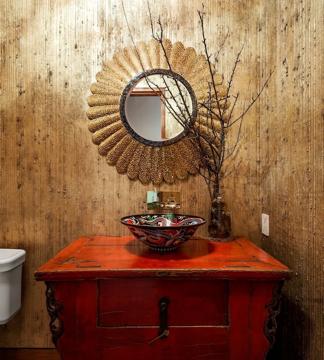 bathroom with vanity and wooden walls