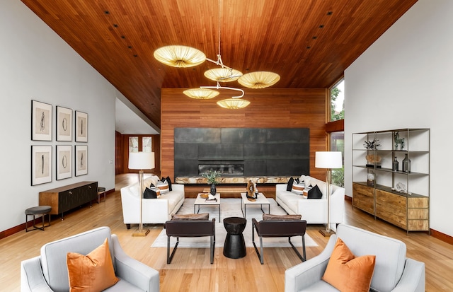 living room featuring hardwood / wood-style floors, wooden walls, high vaulted ceiling, a tiled fireplace, and wooden ceiling