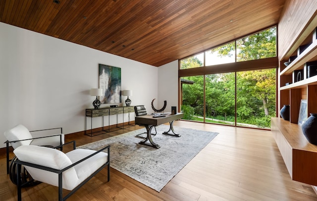 sitting room with wood ceiling, floor to ceiling windows, light hardwood / wood-style flooring, and a high ceiling