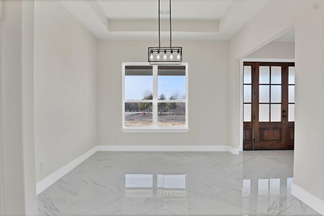 unfurnished dining area with a raised ceiling