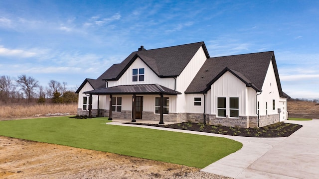 modern inspired farmhouse featuring covered porch and a front yard