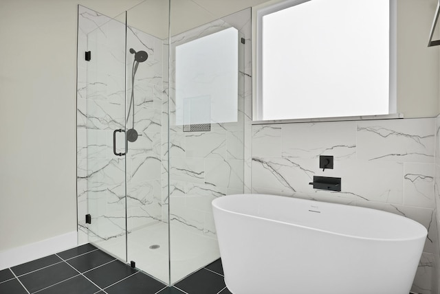 bathroom with shower with separate bathtub and tile patterned floors