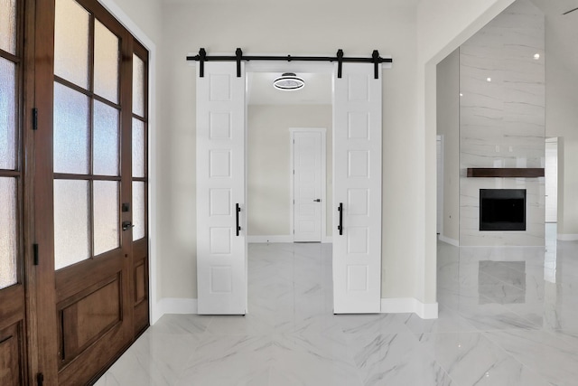 entrance foyer featuring a large fireplace, a wealth of natural light, and a barn door