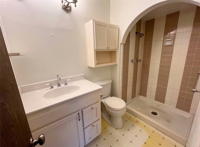 bathroom featuring vanity, toilet, and tiled shower