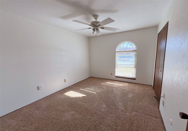 carpeted empty room featuring ceiling fan