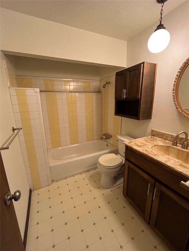 full bathroom featuring tiled shower / bath, vanity, toilet, and a textured ceiling