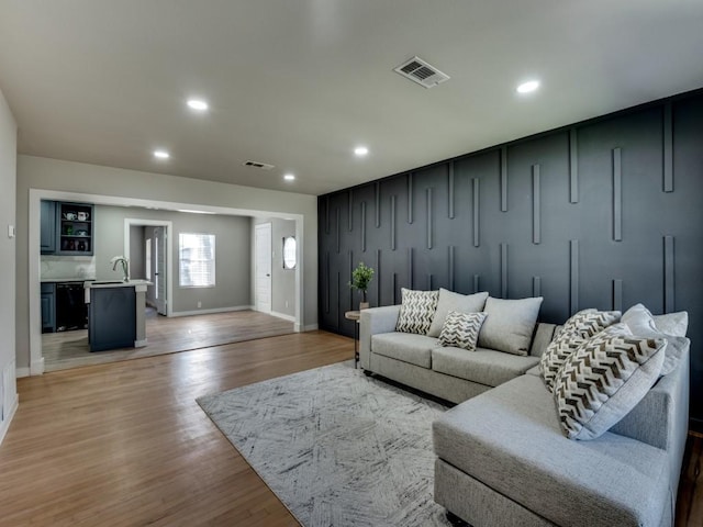 living room with wet bar and light hardwood / wood-style floors