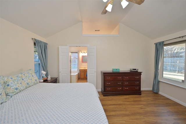 bedroom featuring vaulted ceiling, light hardwood / wood-style floors, ceiling fan, and ensuite bath