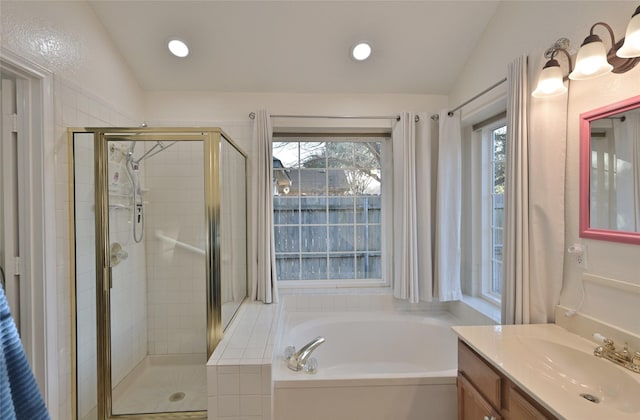 bathroom with vanity, independent shower and bath, and vaulted ceiling