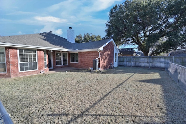 back of house featuring a lawn and a patio