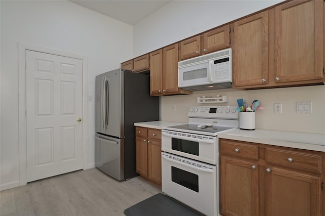 kitchen featuring white appliances and light hardwood / wood-style floors