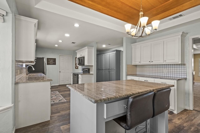 kitchen with tasteful backsplash, stone countertops, black appliances, dark hardwood / wood-style floors, and white cabinets