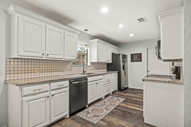 kitchen with appliances with stainless steel finishes, white cabinetry, sink, dark hardwood / wood-style flooring, and decorative backsplash