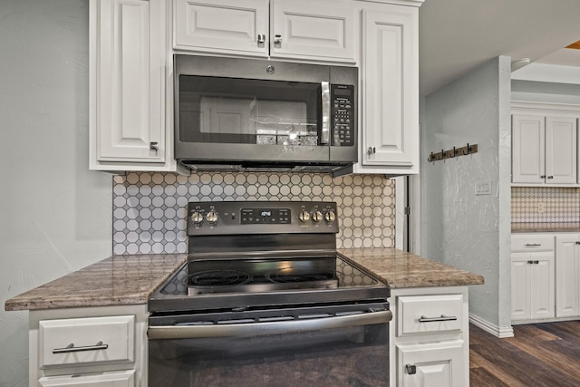 kitchen featuring dark hardwood / wood-style floors, black electric range, white cabinets, decorative backsplash, and dark stone counters