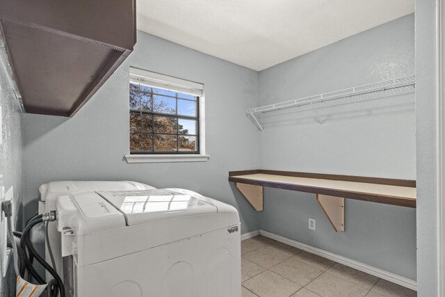 clothes washing area featuring separate washer and dryer and light tile patterned floors