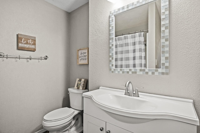 bathroom with vanity, curtained shower, and toilet