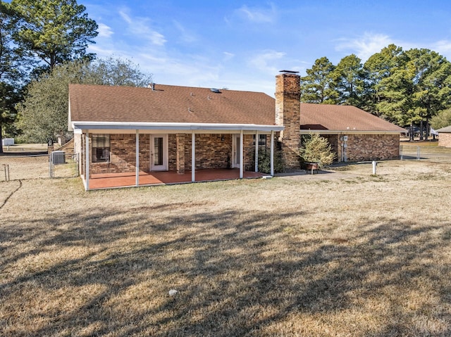 back of property with a patio and a yard