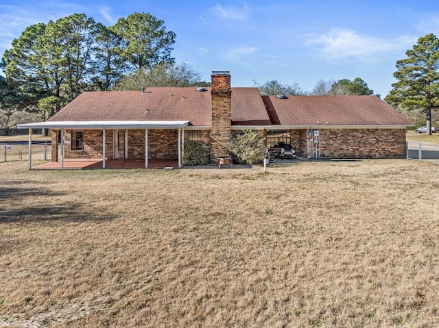 rear view of property featuring a lawn and a patio area