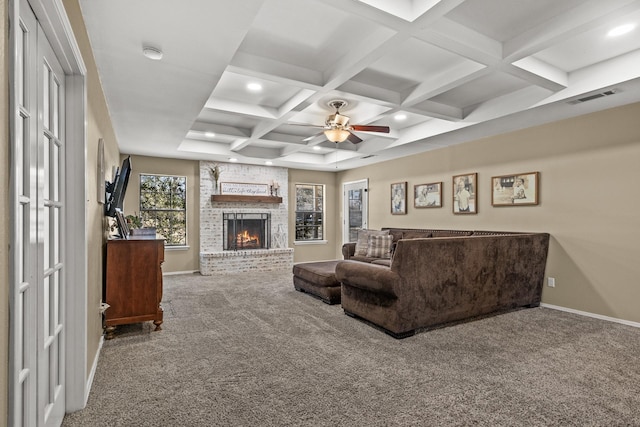 living room featuring a fireplace, beamed ceiling, carpet floors, coffered ceiling, and ceiling fan