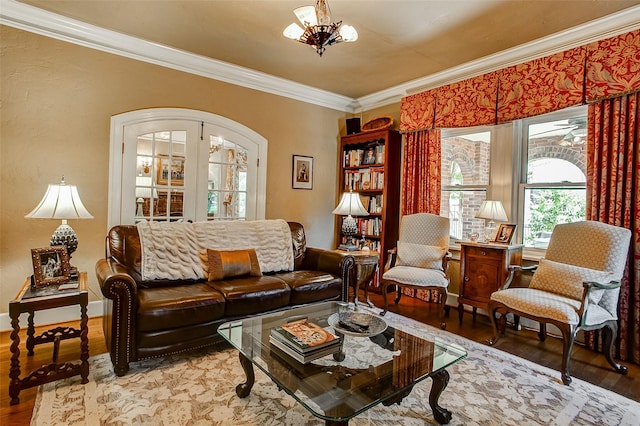 living room featuring arched walkways, crown molding, wood finished floors, french doors, and an inviting chandelier