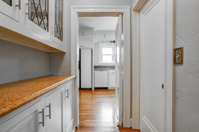 kitchen featuring dishwashing machine, white cabinetry, and a wealth of natural light