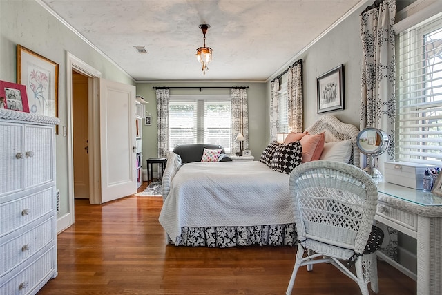 bedroom featuring visible vents, crown molding, and wood finished floors