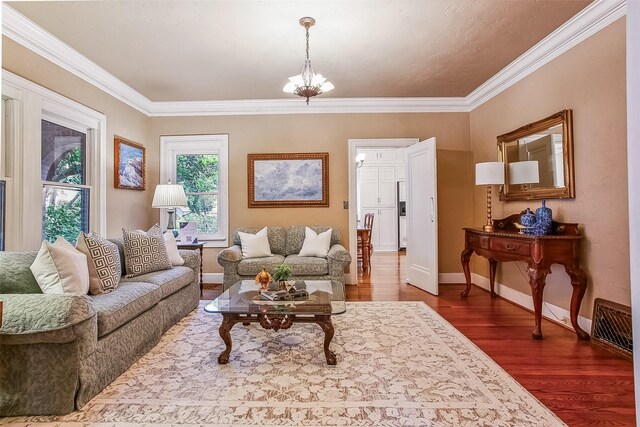 living area featuring arched walkways, a brick fireplace, crown molding, and wood finished floors