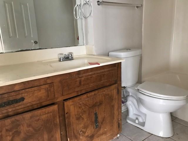 bathroom with tile patterned flooring, vanity, and toilet