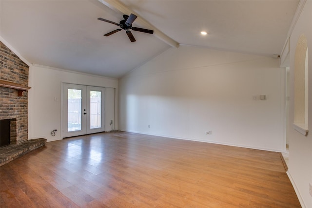 unfurnished living room featuring french doors, lofted ceiling with beams, a brick fireplace, light hardwood / wood-style flooring, and ceiling fan