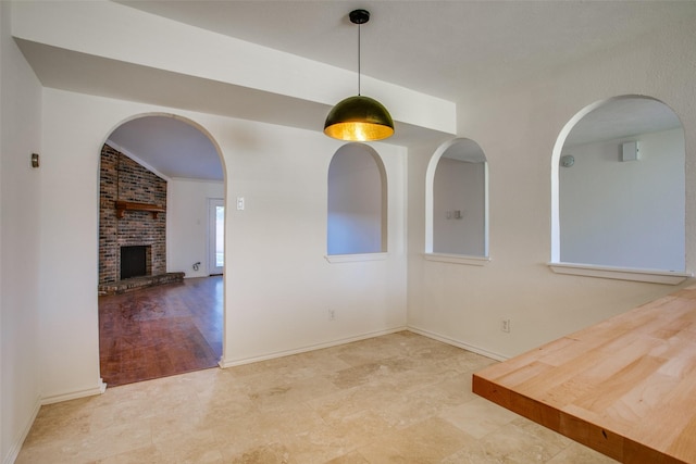 unfurnished dining area with a brick fireplace