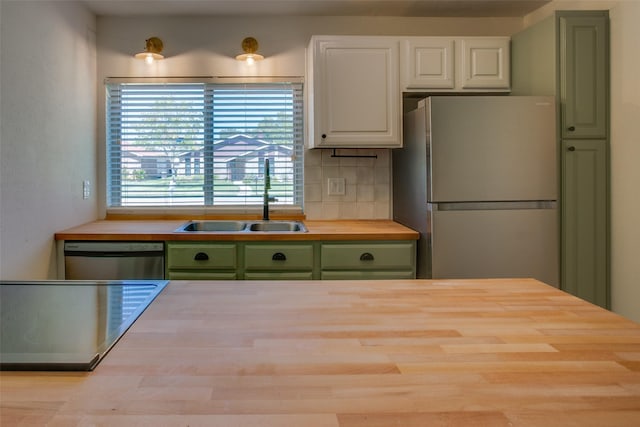 kitchen featuring sink, white cabinetry, appliances with stainless steel finishes, green cabinets, and decorative backsplash