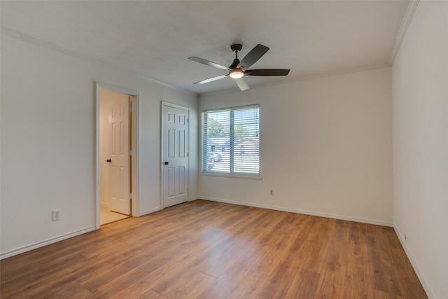 spare room with hardwood / wood-style floors, crown molding, and ceiling fan